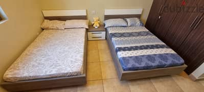 Twin single beds, with pillows, matresses and one nigthstand