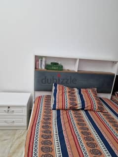 Bed with mattress and side table